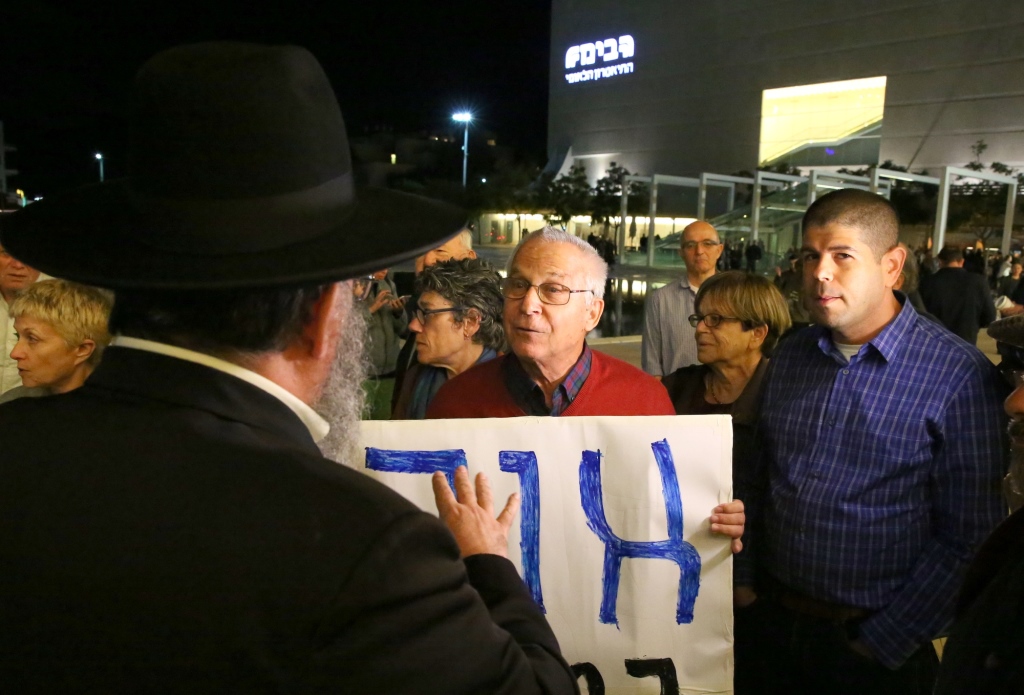 מזכ"ל שלום עכשיו, יריב אופנהיימר מפגין מחוץ לאולם (עזרא לנדאו)